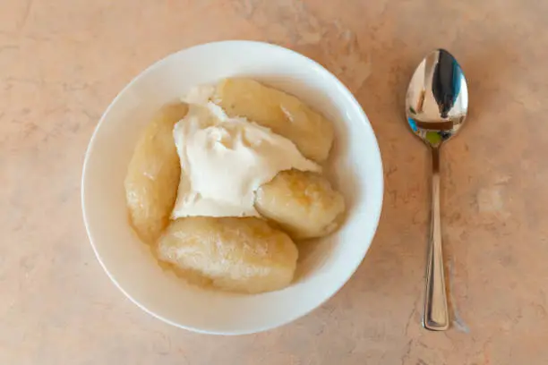 Photo of Traditional Lithuanian dish meal cuisine, stuffed meat potato dumpling,most popular Lithuanian national dish on a plate near spoon.