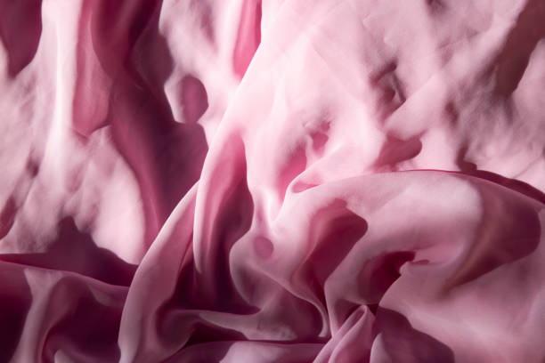 istock Gentle Waves of Pastel Pink Silk background. Natural light 1994955872