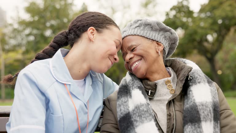 Nurse, happy and friends with old woman on park bench for retirement, elderly care and support. Trust, medical and healthcare with african patient and caregiver in nature for nursing rehabilitation