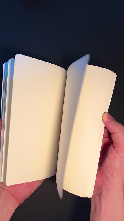 Human hands quickly leafing through the blank pages of a book