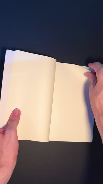 Human hands slowly leafing through the blank pages of a book