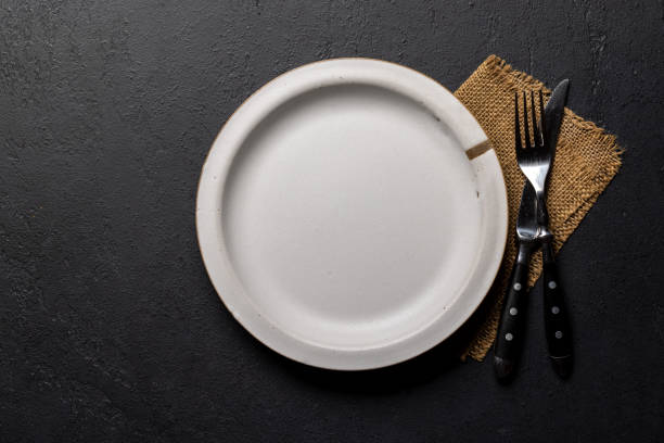 istock Mockup for a delicious meal. Empty plate on a table 1995004362