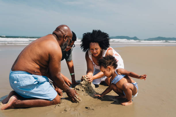 istock Parents and their children playing on a sandy beach in summer 1995008080