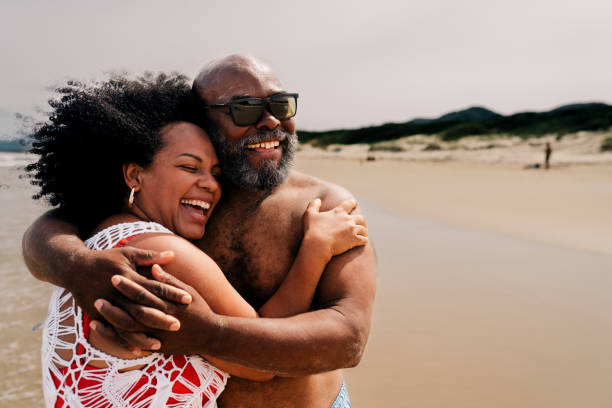 istock Loving mature couple laughing on a sandy beach in summer 1995008976