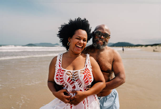 istock Smiling mature couple standing on a sandy beach in summer 1995009139