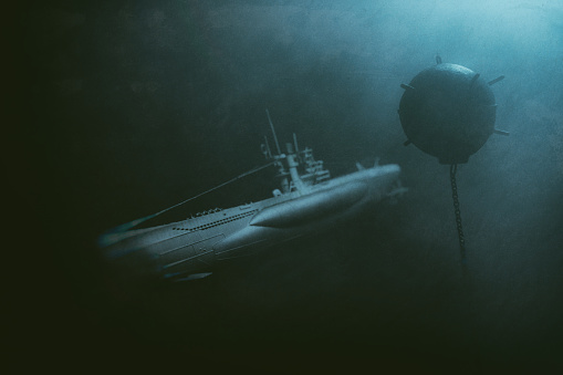 A World War II era U-Boat submarine navigating the depths of an ocean, passing perilously close to an old-fashioned contact sea mine.