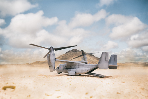 A Bell-Boeing CV-22 Osprey tilt-rotor military aircraft, as used by the US military, seen here in an arid desert environment. Scale model photography.