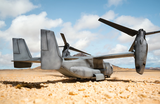 A Bell-Boeing CV-22 Osprey tilt-rotor military aircraft, as used by the US military, seen here in an arid desert environment. Scale model photography.