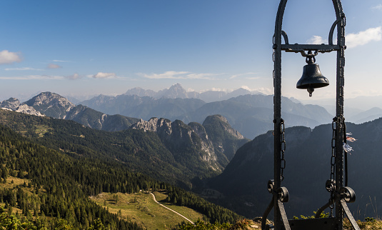 View from Mount Auernig to the Julian Alps with the summit bell in the front at a beautiful sunny autumn day