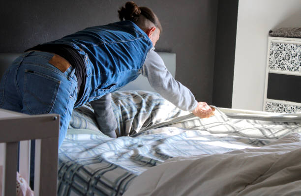 istock Man making the bed in the bedroom 1995044024