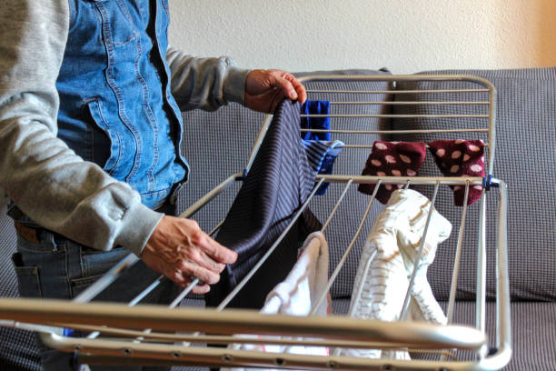 istock Caucasian man hanging clothes inside the house 1995049846