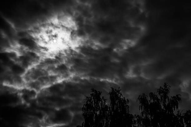 moon glowing through the clouds at night with a strong thunderstorm front during rain