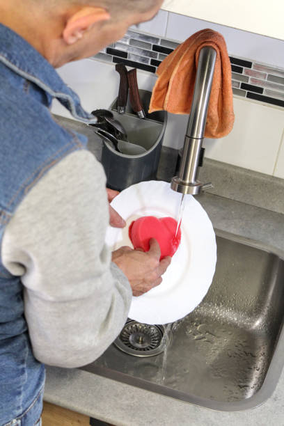 istock Man washing dishes in the kitchen 1995056224