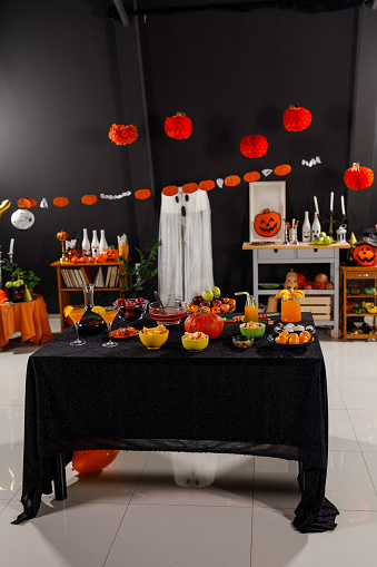 Copy space shot of a set up decorated for a fun Halloween party with drinks and snacks served on a table.