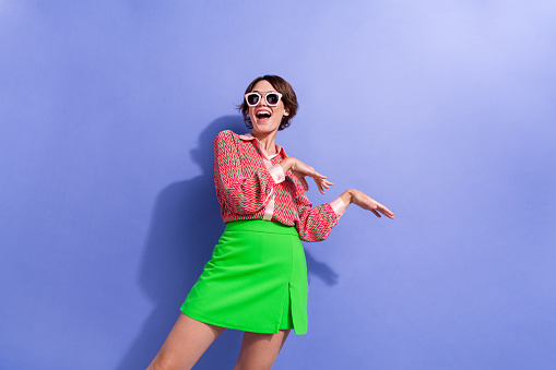 Portrait of good mood nice girl with short haircut wear shirt in sunglass dancing celebrate black friday isolated on blue color background.