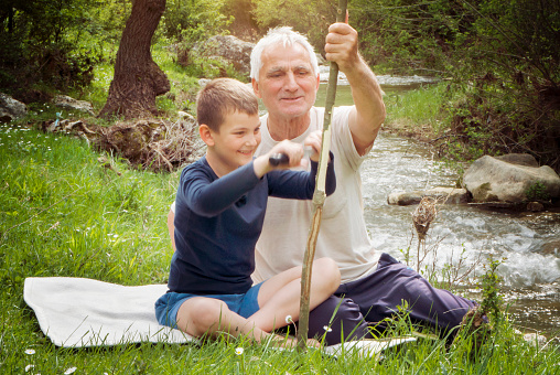 Grandfather teaching grandson woodwork