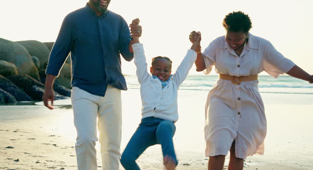 Family, child and holding hands for swing at beach, together and fun on vacation to Hawaii. Black man, woman and kid with smile for bonding, love or care on adventure by sea, ocean or coast in summer