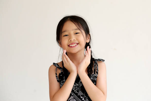 Portrait of young Asian girl against white background