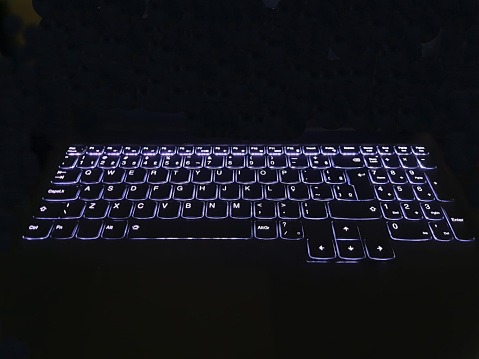 Laptop keyboard lighting, front view on a black background.