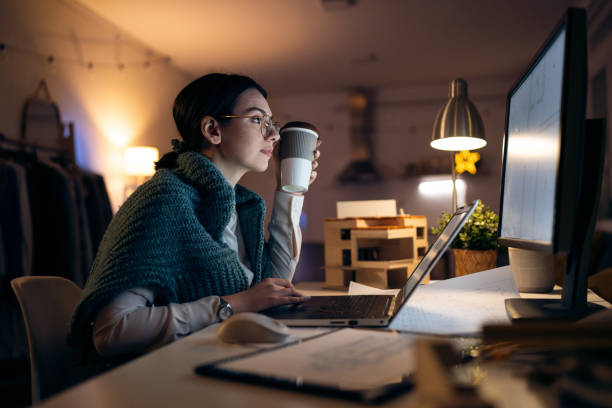 istock Young female architect working late in her home office 1995169211