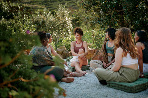Diverse women talking in a circle outside at a scenic wellness retreat