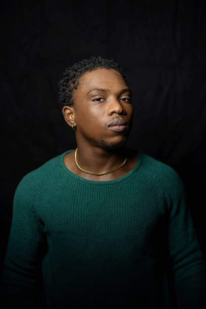istock Young African man gazes at the camera against black background 1995178181