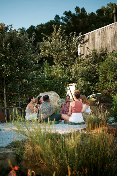 istock Smiling women talking in a circle while sitting outdoors at a wellness retreat 1995180363