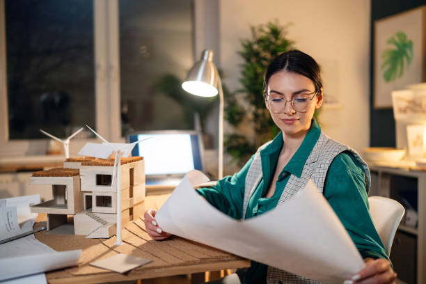 istock Young female architect working late in her home office 1995187315