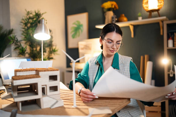 Young female architect working late in her home office