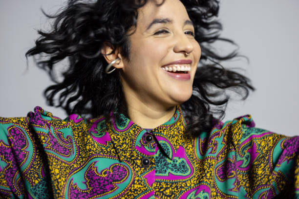istock Happy young latin woman enjoying herself on grey background 1995191052