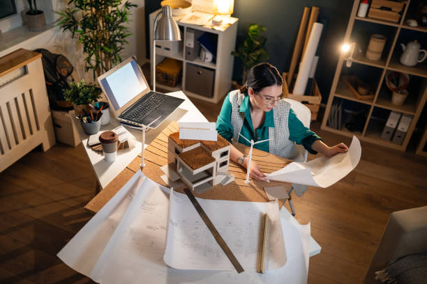 istock Young female architect working late in her home office 1995196089