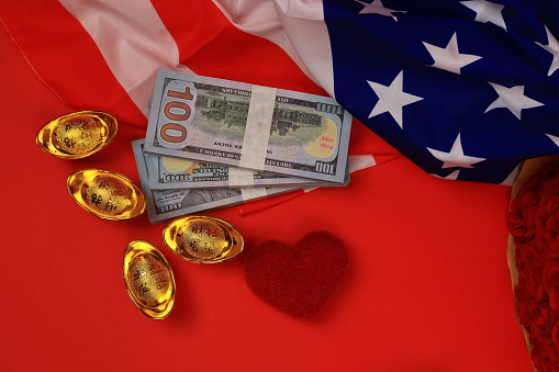American flag with cash us dollar and golden ingot with  heart shape  in a red  background for copy-paste text