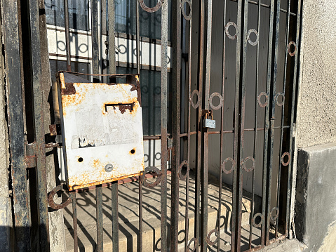 Ruined mailbox and padlock on the metal door