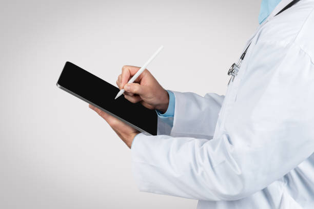istock Man doctor using stylus on tablet for patient records 1995241463