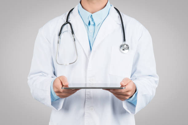 istock Medicine and technologies. Unrecognizable male doctor using digital tablet, standing on grey studio background 1995241518