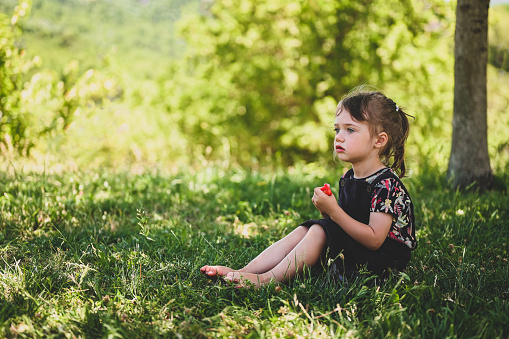 A boy and a girl 4-6 years old in white outfits running in a flowering meadow chamomile field