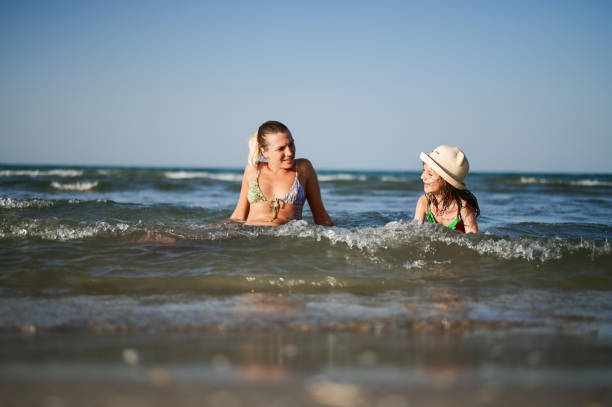 Family relaxing in a warm sea waves.