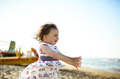 Baby girl running on a beach.