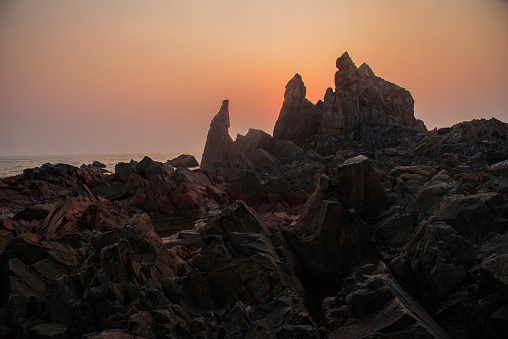 Rock formation with beautiful sunset at Arambhol beach, Goa. India.