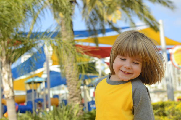 positive boy 4 years old at the playground. bright playground, palm trees, good mood. the face of the child, positive emotions - surprise child 4 5 years little boys zdjęcia i obrazy z banku zdjęć