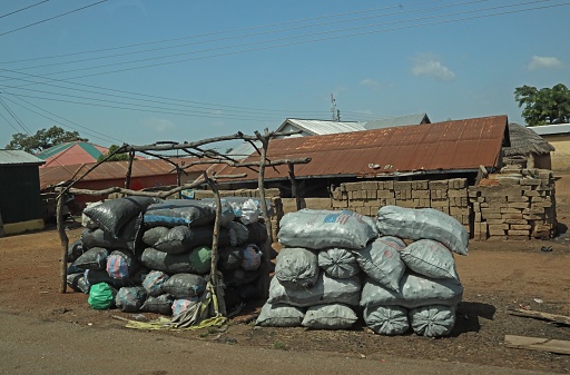 charcoal stacked by the road for sale\n\nnorthern Ghana, Africa.         December