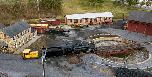 An Drone View of a Narrow Gauge Steam Locomotive Getting off a Turntable and Steaming Up for the Days Work on a Sunny Spring Day