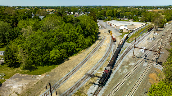 An Aerial View of a Steam Locomotive Moving Freight Cars Around in a Freight Yard to Organize a Freight Train on a Sunny Day