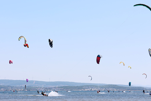 Izmir, Türkiye-08/01/2023: Large group of people practicing kiteboarding.