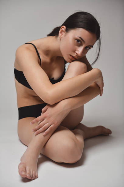 istock Female Looking Shyly While Wearing Her New Black Underwear 1995304404