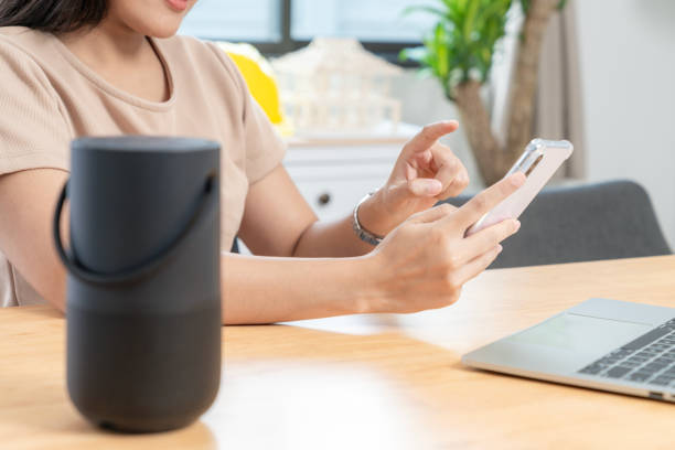 istock Young woman connecting a portable speaker at home 1995313031
