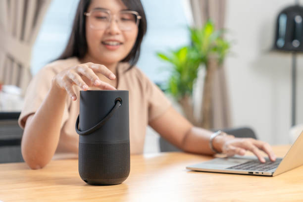 istock Young woman connecting a portable speaker at home 1995313032