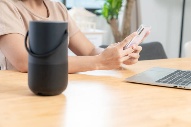 istock Young woman connecting a portable speaker at home 1995313034