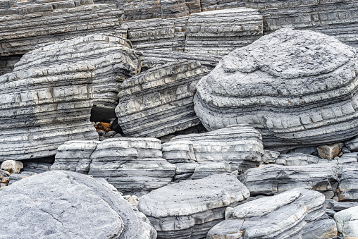 A stunning photograph capturing the natural strata and textures in large coastal boulders near Aberystwyth. This image showcases the unique geological features of the British coastline.