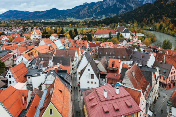 View from above of the old town of Füssen with orange roofed houses and the Lech River at the foot of the Bavarian alps View from above of the old town of Füssen with orange roofed houses and the Lech River at the foot of the Bavarian alps fussen stock pictures, royalty-free photos & images